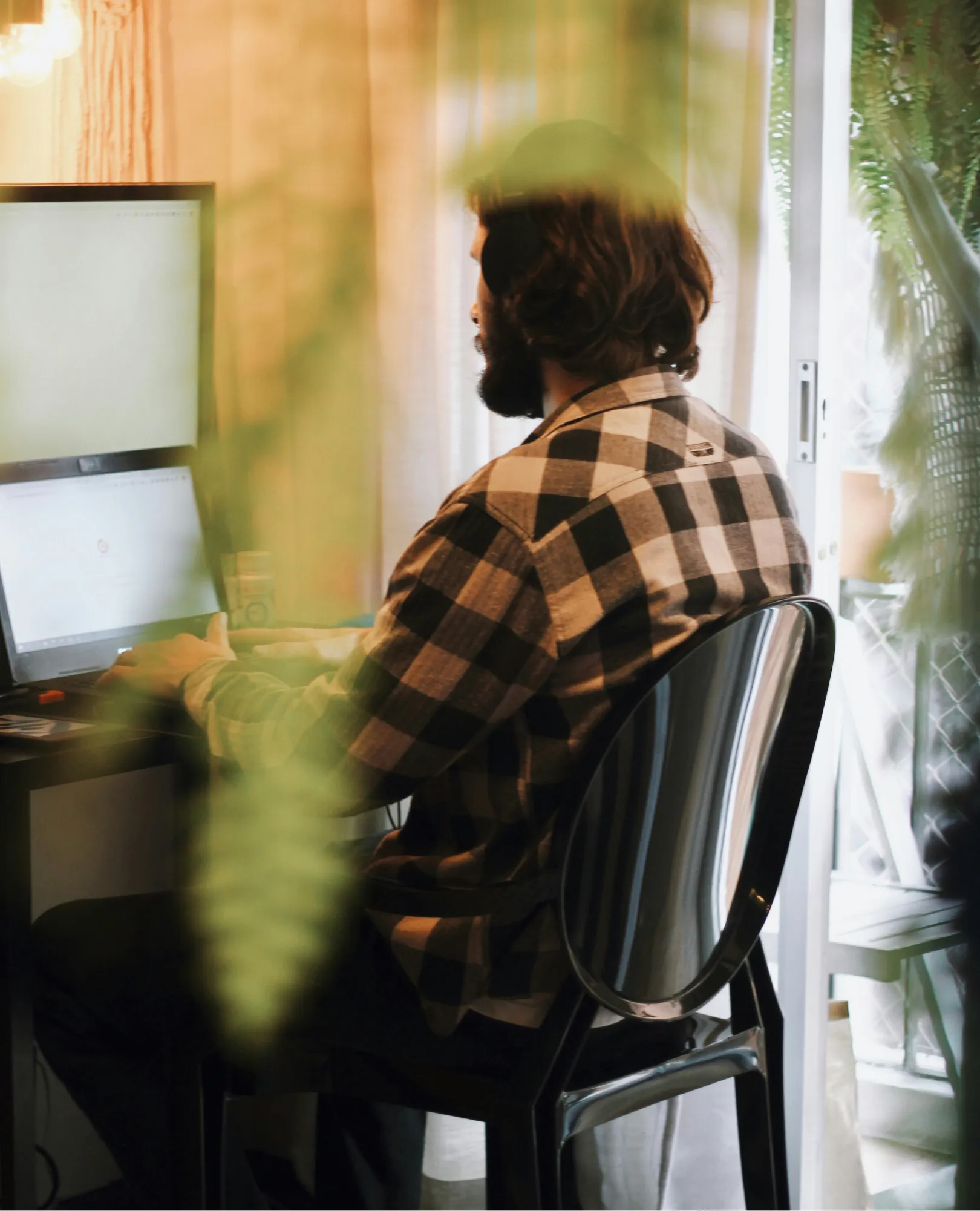 Man working on desktop computer with back turned to camera